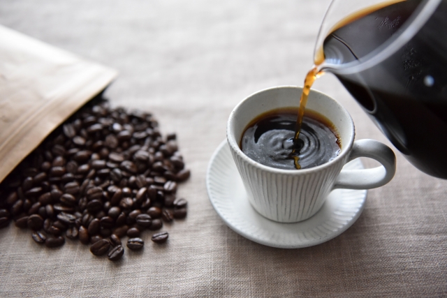 カップに注がれるコーヒーと、コーヒー豆