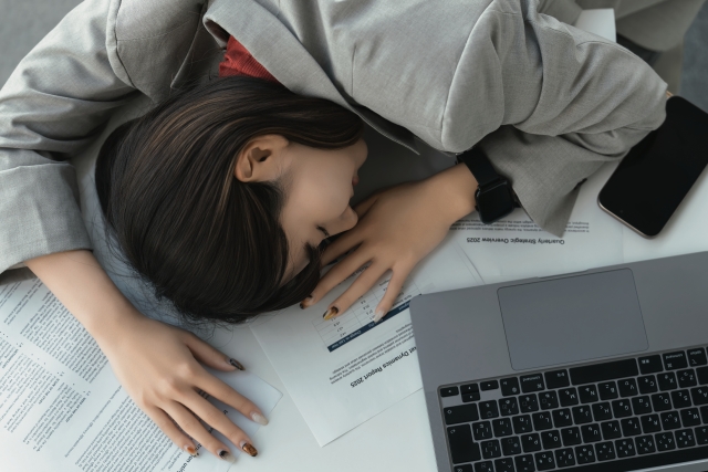 働きすぎて疲れている女性の画像